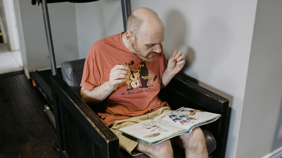 a man sits in an armchair reading a book
