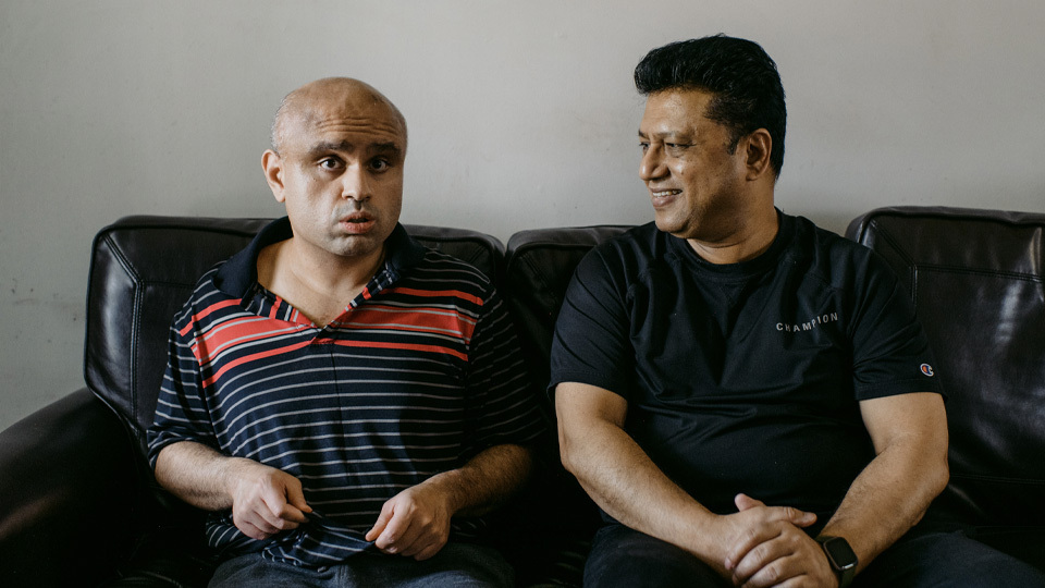 two men sitting on a couch