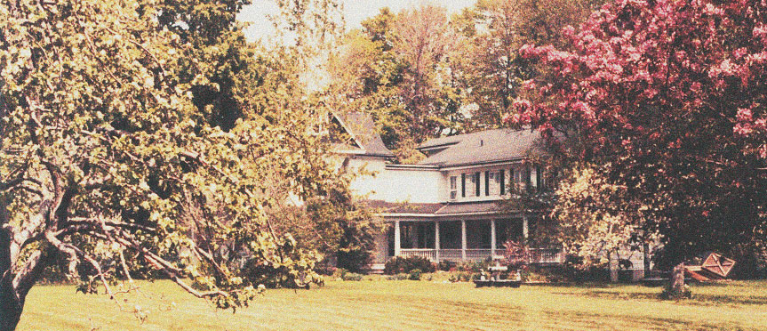 a White House surrounded by trees with green and red leaves