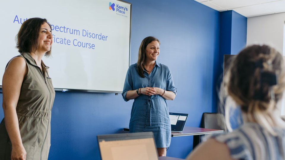 two women standing in front of a group as they give a presentation about an Autism Spectrum Disorder Certificate Course