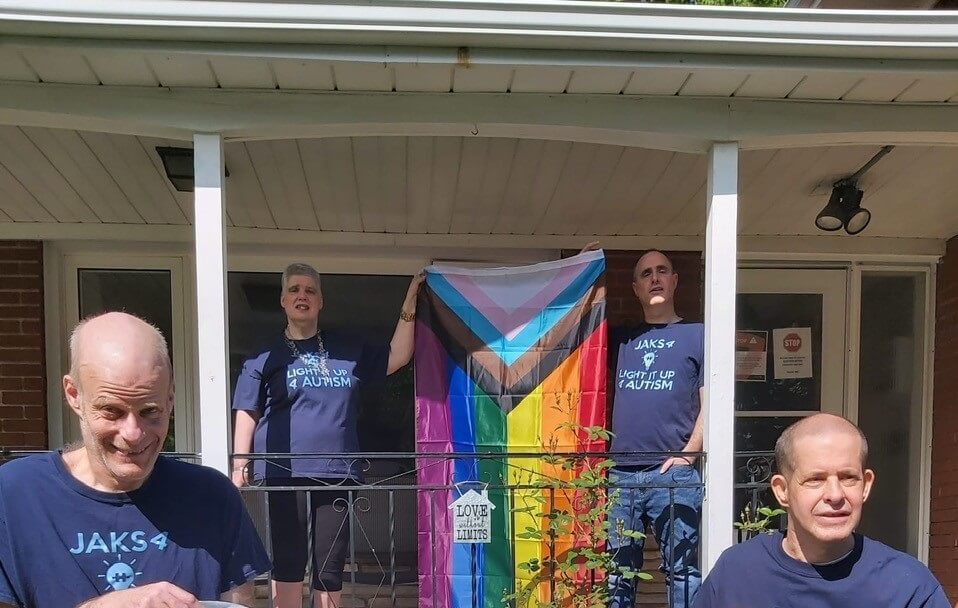 people standing on a porch holding a pride flag