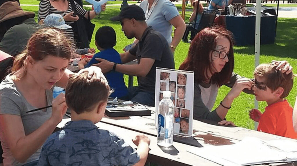 Volunteers painting children's faces at an event